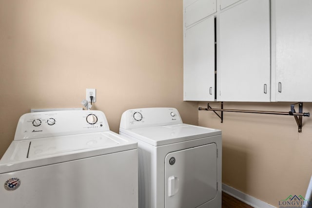 washroom with baseboards, cabinet space, and washer and clothes dryer