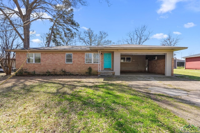 single story home with driveway, entry steps, a front yard, an attached carport, and brick siding