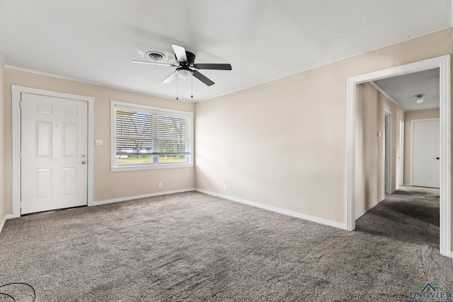 carpeted spare room featuring a ceiling fan and baseboards