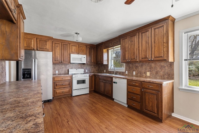 kitchen with white appliances, plenty of natural light, a ceiling fan, and tasteful backsplash