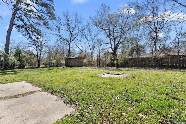 view of yard with an outbuilding, a storage shed, and fence