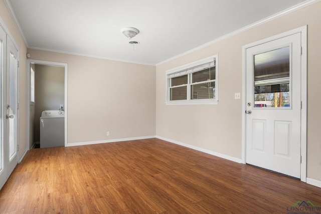 unfurnished room with baseboards, washer / dryer, wood finished floors, and crown molding