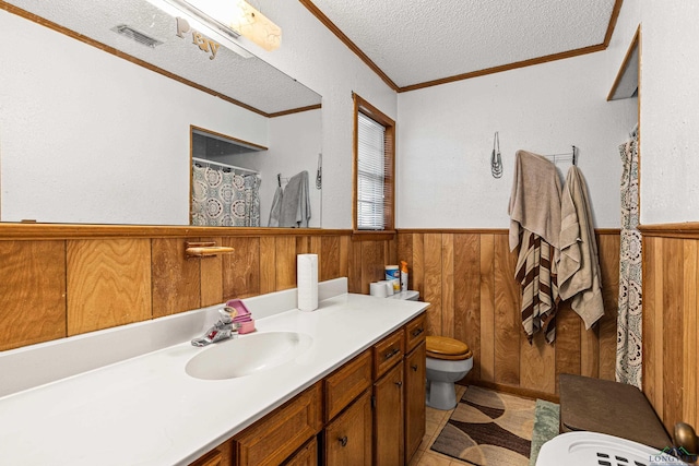 bathroom with tile patterned floors, ornamental molding, vanity, a textured ceiling, and toilet