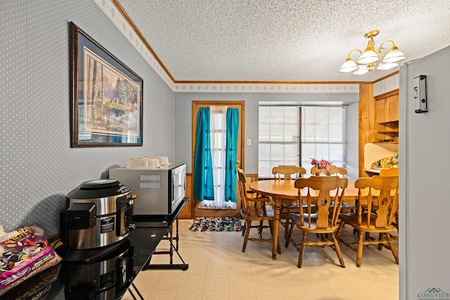 dining room featuring a textured ceiling, crown molding, and a chandelier