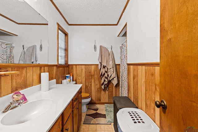 bathroom featuring vanity, toilet, ornamental molding, and a textured ceiling