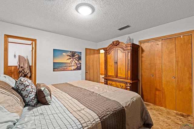 carpeted bedroom featuring a textured ceiling and a closet