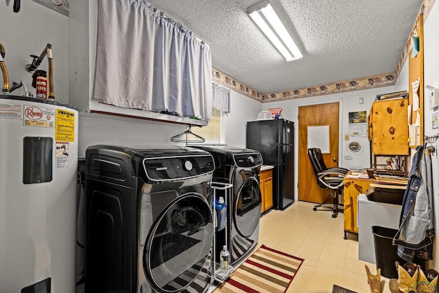 washroom with electric water heater, cabinets, a textured ceiling, and independent washer and dryer