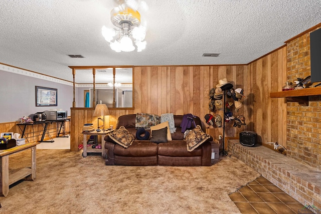 living room featuring carpet floors, a textured ceiling, wooden walls, and ornamental molding