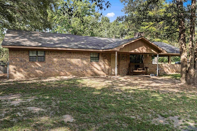 rear view of property featuring a yard