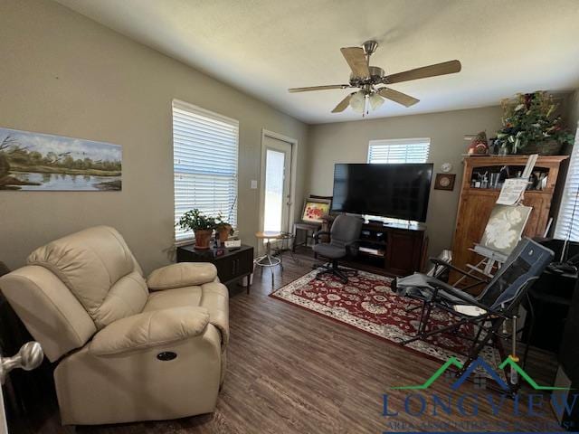 living room featuring dark hardwood / wood-style floors and ceiling fan