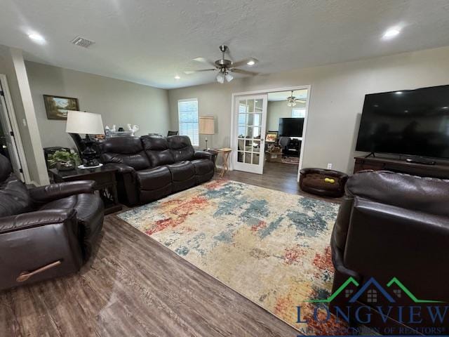 living room featuring french doors, a textured ceiling, and dark wood-type flooring