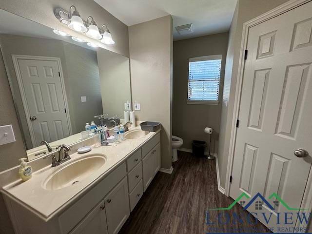 bathroom featuring hardwood / wood-style floors, vanity, and toilet