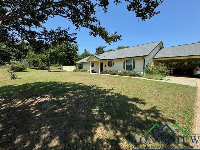 ranch-style house featuring a carport and a front yard