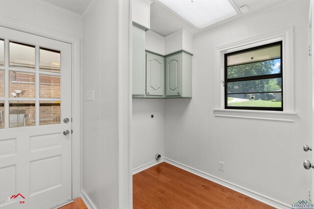 2804 Palm Plz, Marshall, TX 75672 - laundry room featuring hookup for an electric dryer, cabinet space, wood finished floors, baseboards, and ornamental molding