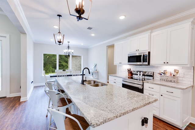 kitchen with backsplash, an island with sink, stainless steel appliances, and a sink