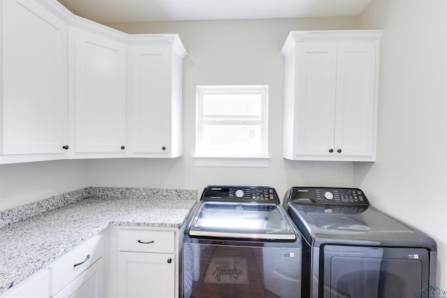 washroom featuring independent washer and dryer and cabinet space