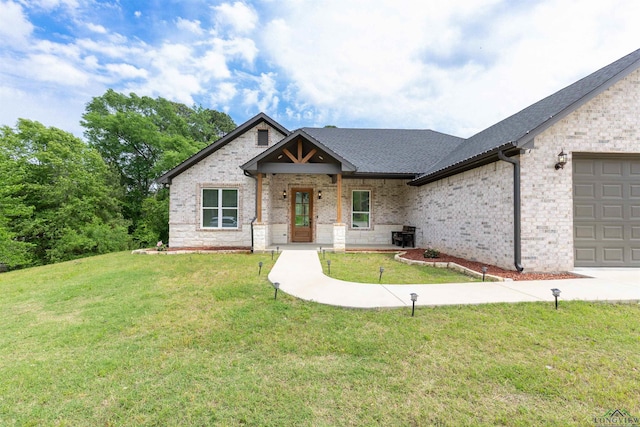 view of front of house with a front lawn, brick siding, and an attached garage