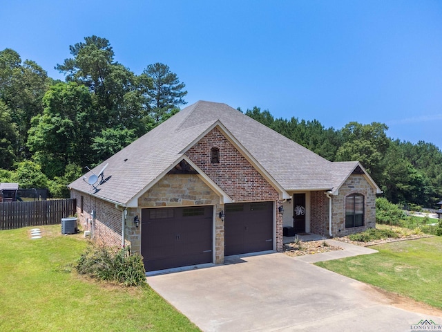 view of front of house featuring a front yard, a garage, and central AC unit