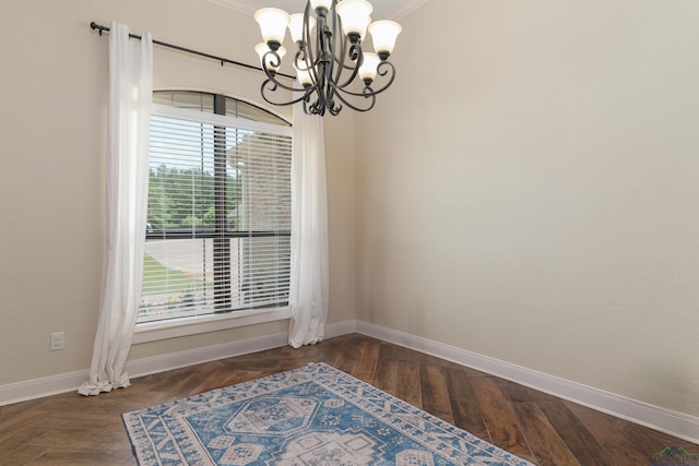 unfurnished room featuring plenty of natural light, dark hardwood / wood-style flooring, ornamental molding, and a chandelier