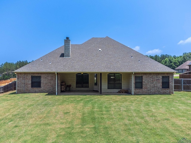 rear view of property with a patio and a lawn