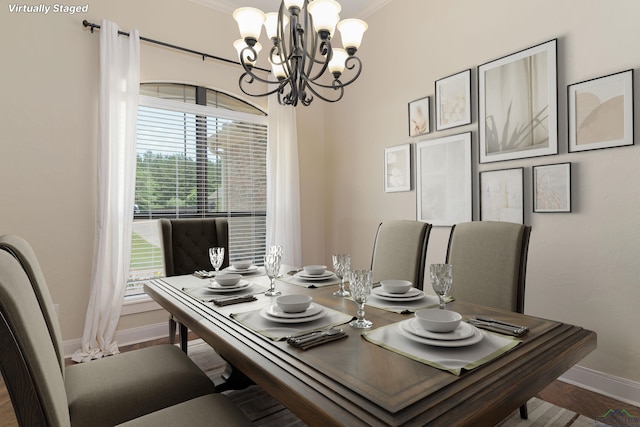 dining room with hardwood / wood-style flooring, a healthy amount of sunlight, and an inviting chandelier