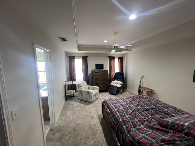 carpeted bedroom with ceiling fan, a raised ceiling, and crown molding