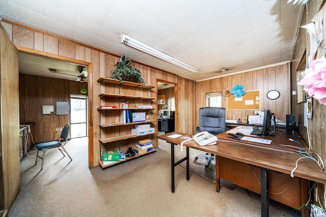 carpeted home office featuring visible vents and wood walls