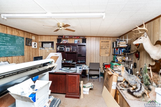 office featuring ceiling fan and wood walls