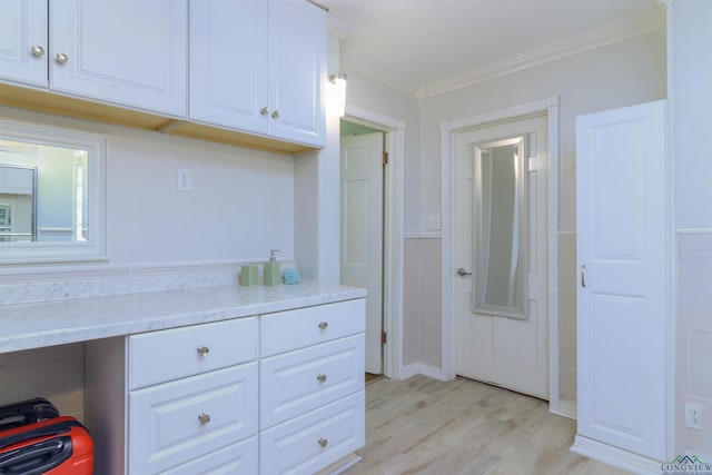 kitchen featuring white cabinets, light hardwood / wood-style floors, and crown molding