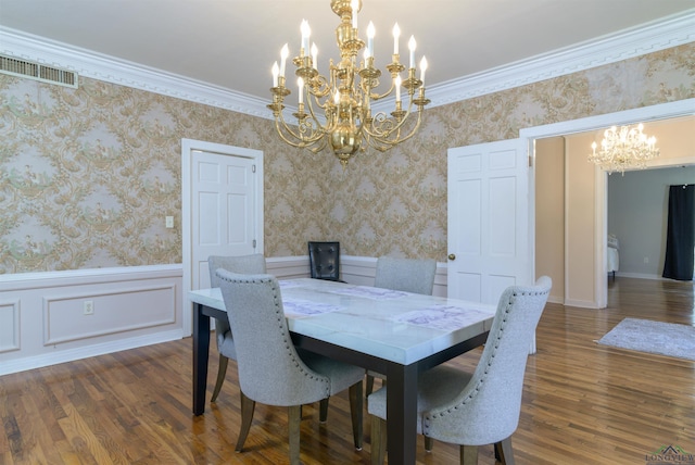 dining room with dark hardwood / wood-style flooring, crown molding, and an inviting chandelier