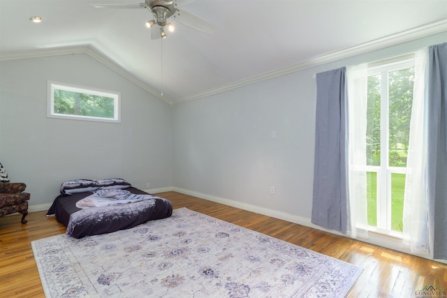 bedroom featuring light hardwood / wood-style flooring, ceiling fan, lofted ceiling, and crown molding