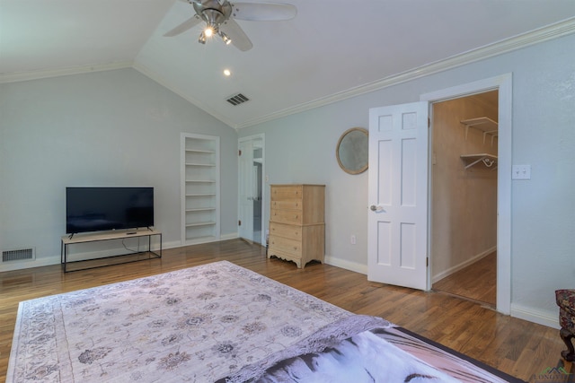 unfurnished bedroom featuring a walk in closet, ceiling fan, crown molding, wood-type flooring, and lofted ceiling