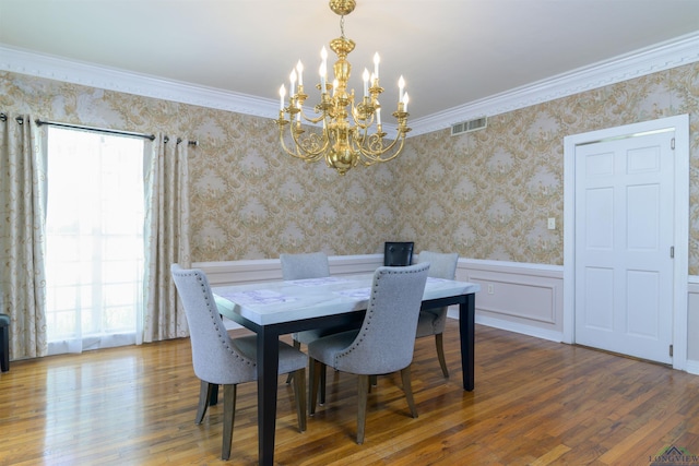 dining space featuring hardwood / wood-style floors, an inviting chandelier, and crown molding