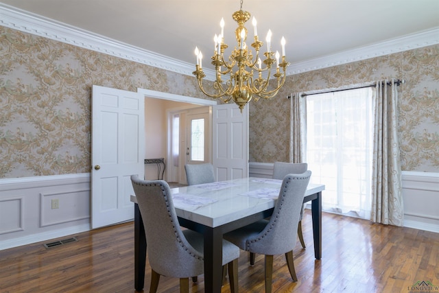 dining room featuring dark hardwood / wood-style flooring, an inviting chandelier, plenty of natural light, and ornamental molding