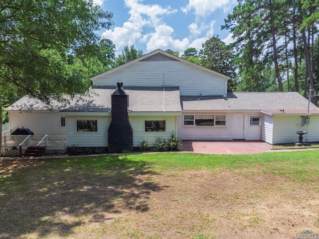 rear view of property featuring a lawn and a patio area