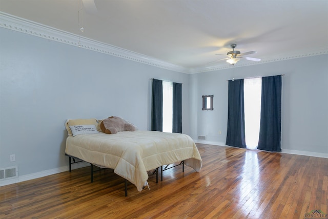 bedroom featuring ceiling fan, crown molding, and dark wood-type flooring