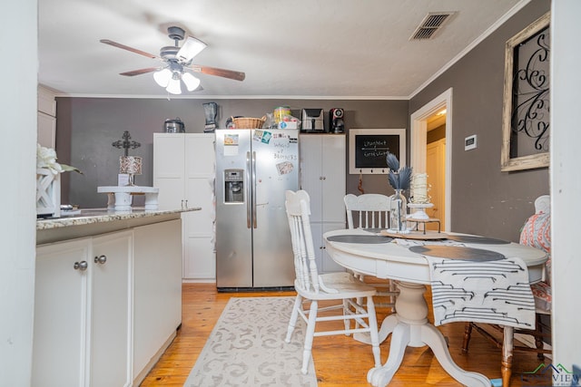 kitchen featuring ornamental molding, visible vents, white cabinetry, and stainless steel refrigerator with ice dispenser