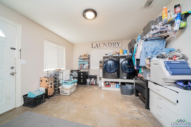 storage area with visible vents and washer and clothes dryer