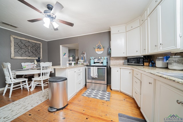 kitchen with light stone counters, light wood finished floors, visible vents, appliances with stainless steel finishes, and white cabinets