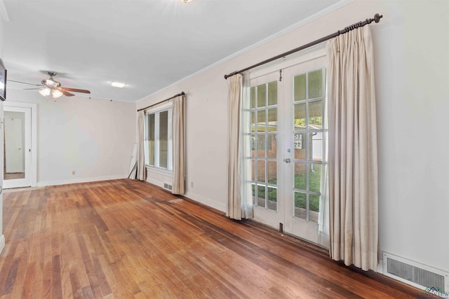 unfurnished room featuring ceiling fan, french doors, hardwood / wood-style floors, and ornamental molding