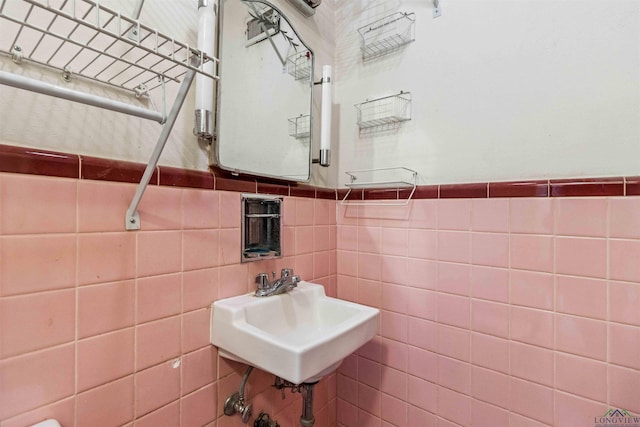 bathroom with sink and tile walls