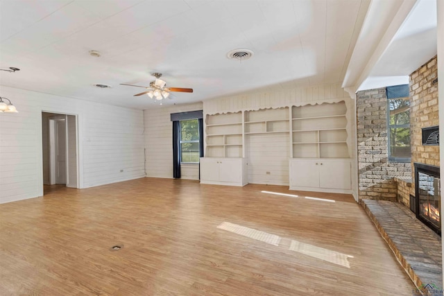 unfurnished living room with a fireplace, light hardwood / wood-style flooring, a wealth of natural light, and ceiling fan