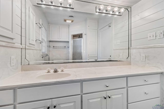 bathroom with vanity and a shower with shower door