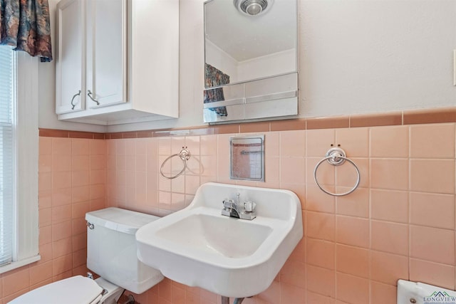 bathroom featuring sink, ornamental molding, tile walls, and toilet