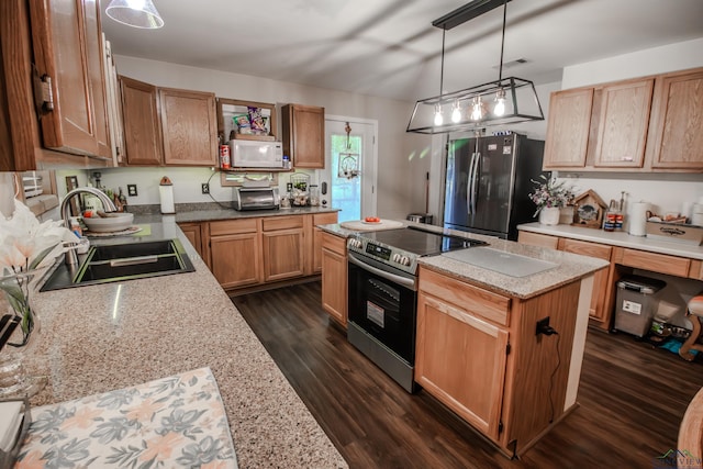 kitchen featuring pendant lighting, sink, a kitchen island, light stone counters, and stainless steel appliances