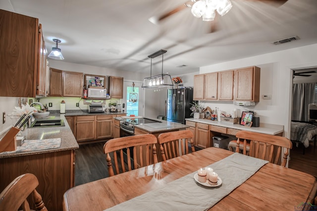 kitchen featuring ceiling fan, sink, hanging light fixtures, dark wood-type flooring, and appliances with stainless steel finishes