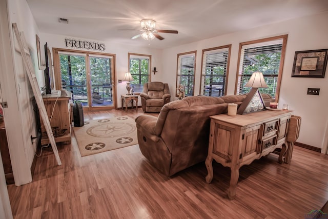 living room with ceiling fan and light wood-type flooring