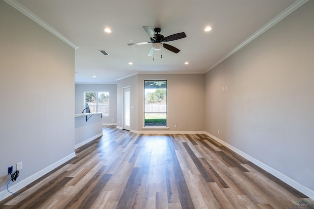 unfurnished living room with wood-type flooring, ceiling fan, and crown molding