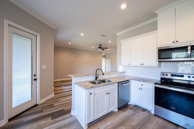 kitchen with white cabinetry, sink, stainless steel appliances, kitchen peninsula, and light wood-type flooring