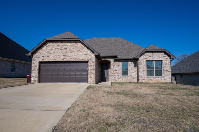 french provincial home with a front lawn and a garage